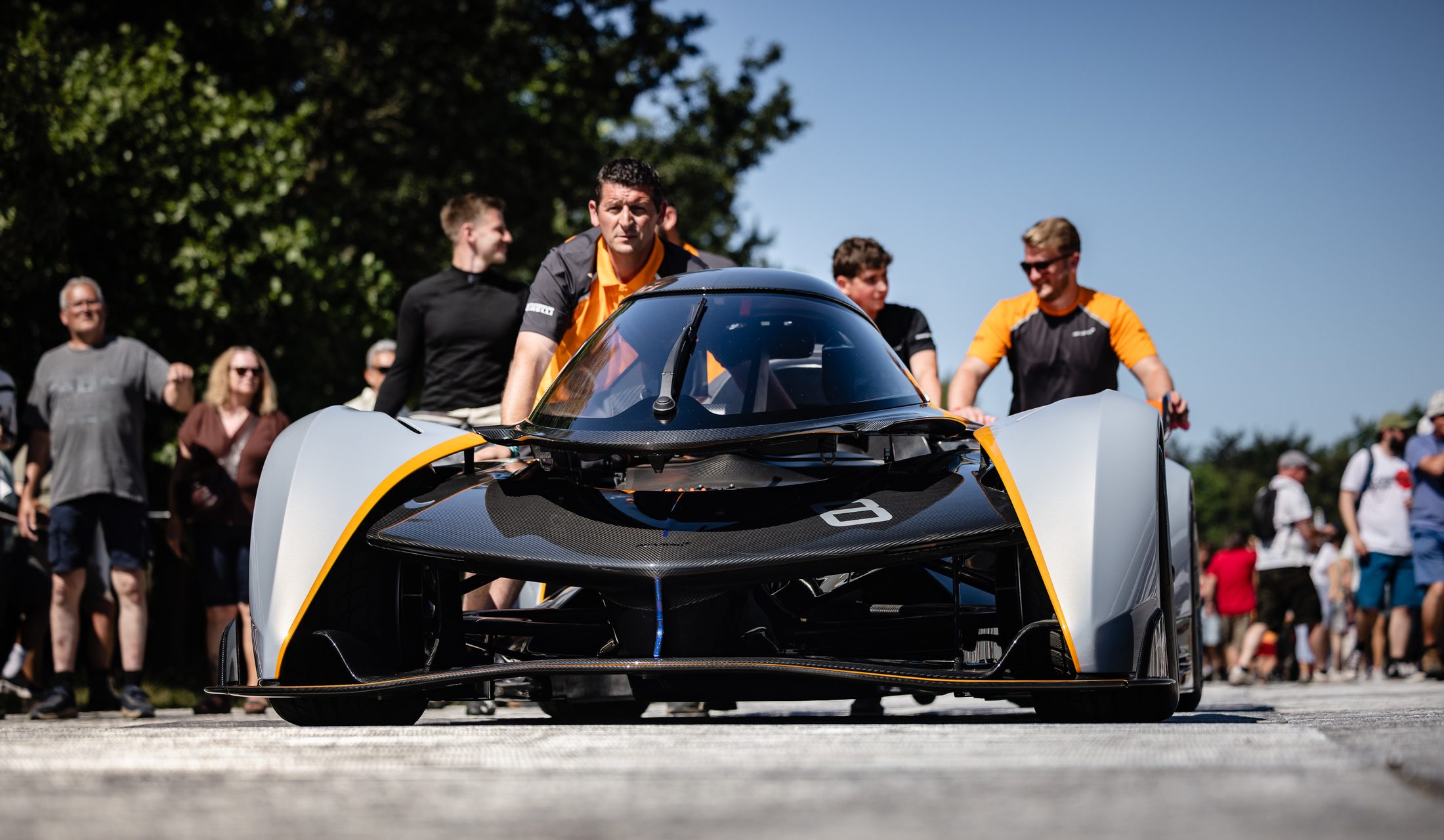 Crew pushing the McLaren Solus GT through the crowd at Goodwood