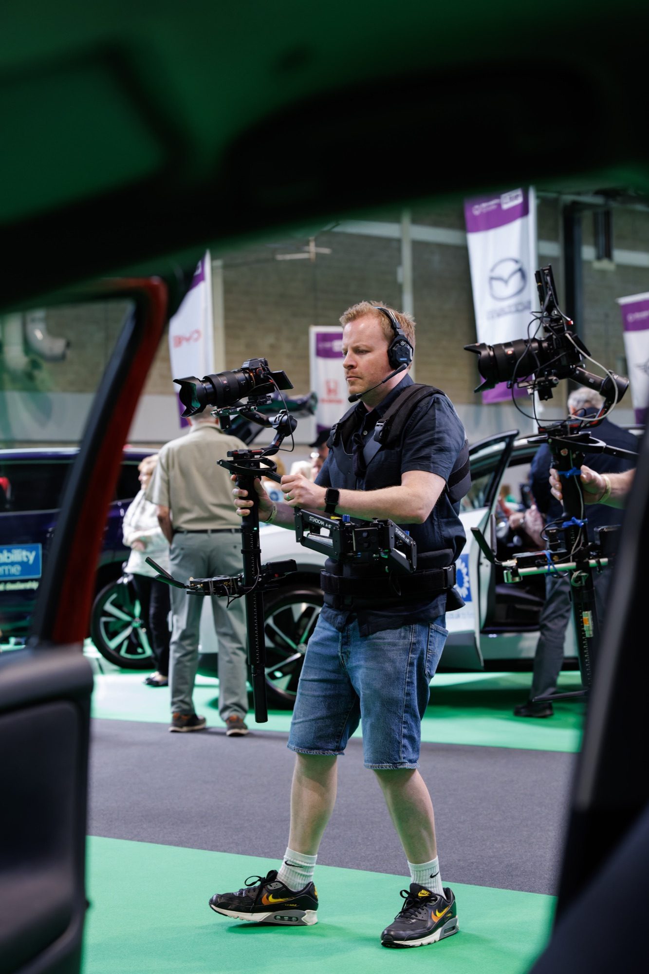 A Steadicam operator moving through the hall past the cars