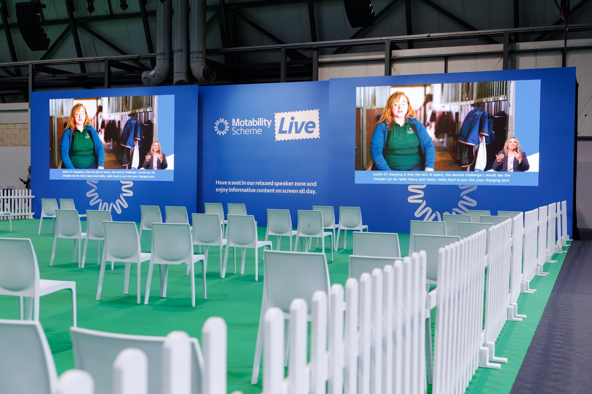 The stage IRIS built into the hall: two large LED screens branded Motability Scheme Live, with rows of seating